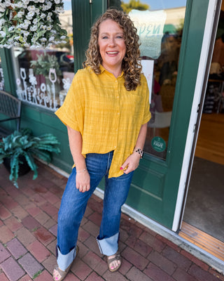 a textured short sleeve button down top in the color mustard gold