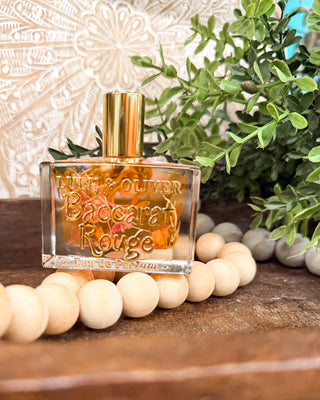 a clear perfume bottle filled with floral pieces
