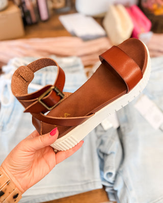 a brown ankle strap sandal with white platform bottom