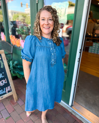 a short sleeve denim chambray dress with pearl button ruffle details