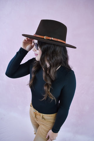 a felt wide brim hat with leather belt strap