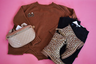 Rust colored sweater with an uneven style hem