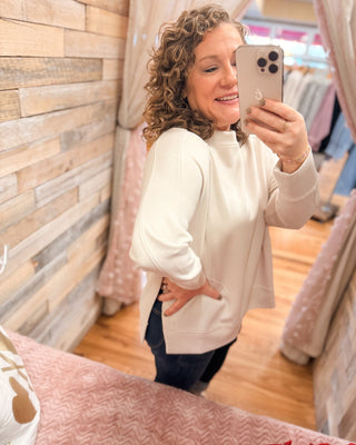 a long sleeve pullover in scuba soft material with a side slit