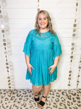 A lightweight bell sleeve style dress in a teal color