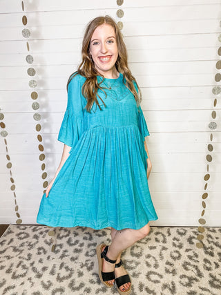 A lightweight bell sleeve style dress in a teal color