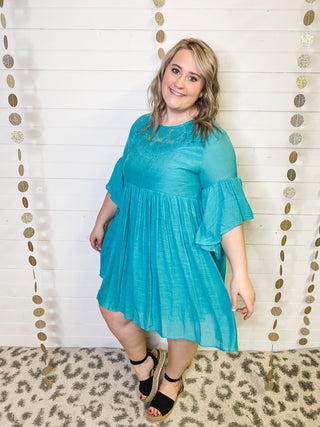 A lightweight bell sleeve style dress in a teal color